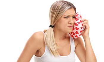 woman putting cold compress on face
