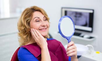 woman seeing her new smile with dental implants in Worthington, OH