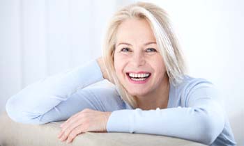 woman sitting on couch and grinning