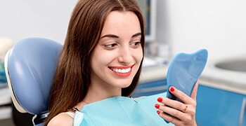 woman smiling into blue mirror